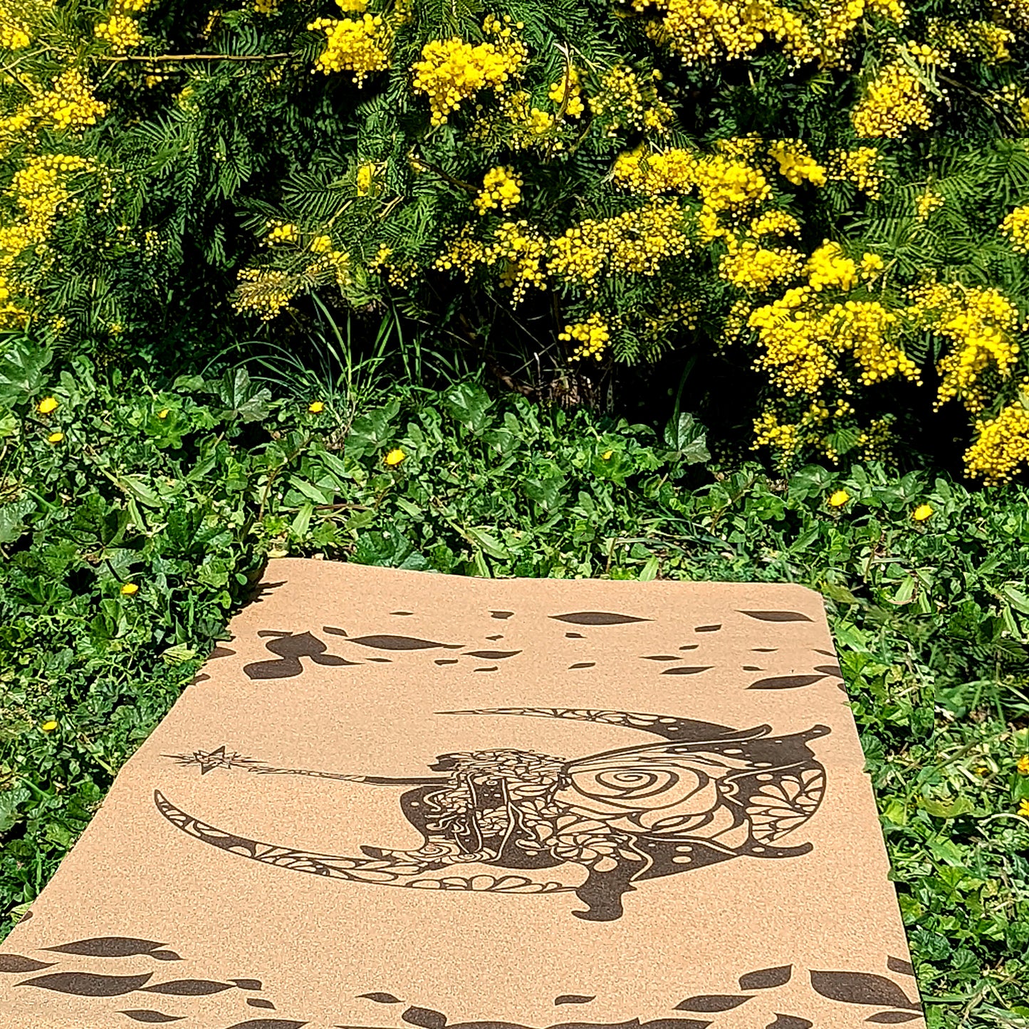 Tapis de yoga en liège Fairy Tale de ZenMotion. Plongez dans un univers enchanté le tapis est capturé ici dans un champ bucolique sous un mimosa. Inspiré des fées, ce design délicat mêle motifs mandalas et une rose cachée, symbolisant légèreté, créativité et magie. Le liège naturel offre une adhérence ultime et un confort inégalé, parfait pour une pratique fluide de Hatha ou de Yin yoga. Éco-responsable et élégant, ce tapis transforme chaque séance en une expérience spirituelle et imaginative.