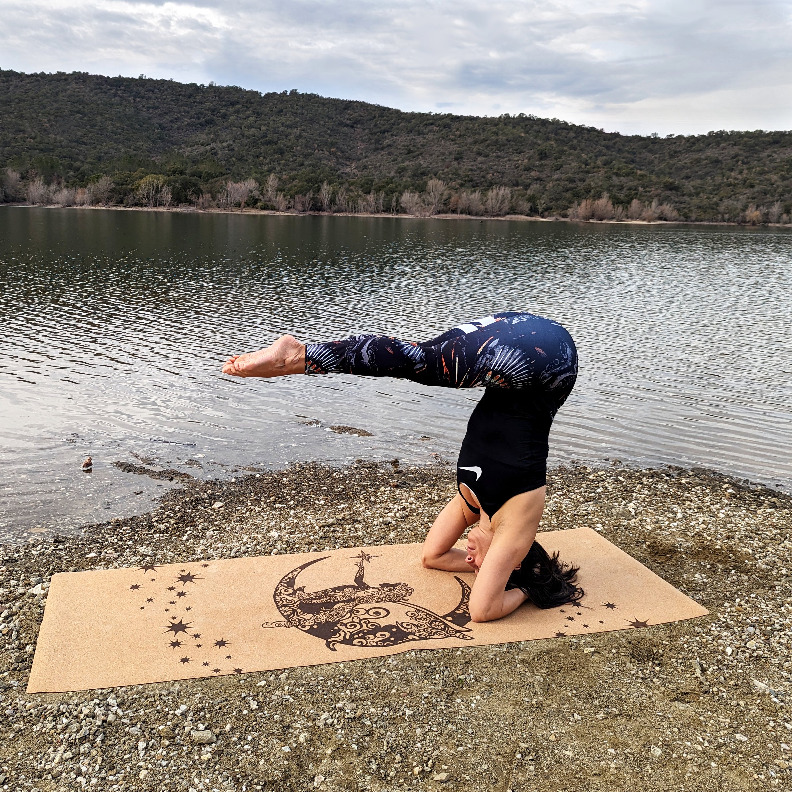 Femme réalisant un headstand (posture sur la tête) sur le tapis de yoga en liège Fairy Night de ZenMotion. Ce tapis écologique et poétique, orné d'une fée et d'étoiles scintillantes, incarne la magie, la transformation et l'intuition. Conçu pour une pratique enchanteuse, il apporte légèreté, joie et inspiration, idéal pour le Hatha, Vinyasa et la méditation avec son adhérence inégalée. Un compagnon unique pour une pratique spirituelle.