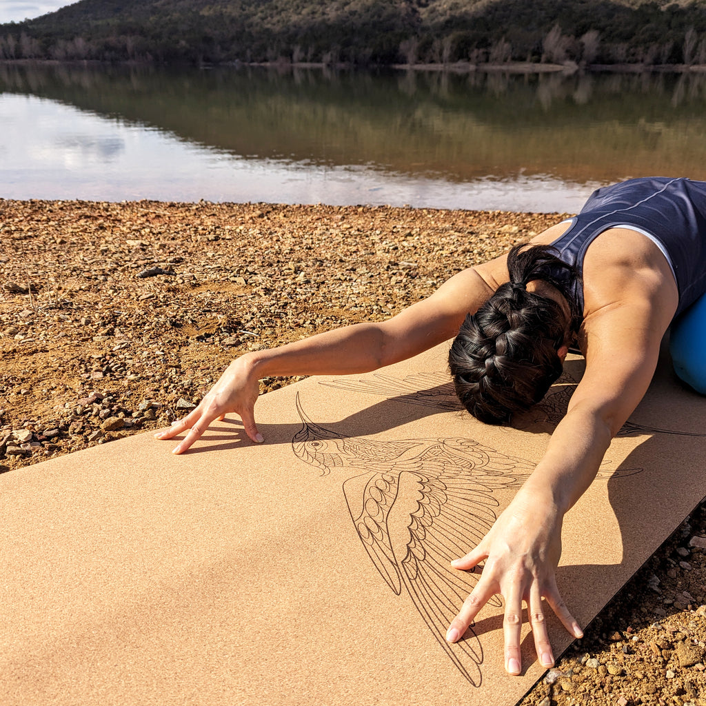 Yogini en balasana sur le tapis de yoga en liège Flying Jewels de ZenMotion orné de deux colibris en miroir, symboles de joie, résilience et d’harmonie. Ce design épuré et symétrique invite à une pratique fluide et mindful, parfaite pour la méditation ou le Vinyasa. Le liège naturel offre une adhérence ultime, antidérapante et confortable, idéale pour améliorer votre équilibre et votre alignement. Éco-responsable et élégant, ce tapis allie fonctionnalité et beauté. Chaque séance est expérience spirituelle