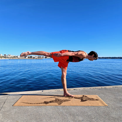 Yogi faisant le guerrier 3 sur le tapis en liège Koru Sharks de ZenMotion. Améliore votre posture et équilibre pour une pratique fluide et sereine, que ce soit en hatha yoga, vinyasa ou ashtanga. L'adhérence incomparable du liège, naturellement antidérapant, soutient chaque mouvement. Fabriqué à partir de matériaux naturels. Fabriqué à partir de matériaux naturels, durables et recyclables, ce tapis éco-responsable est une œuvre d'art fonctionnelle.