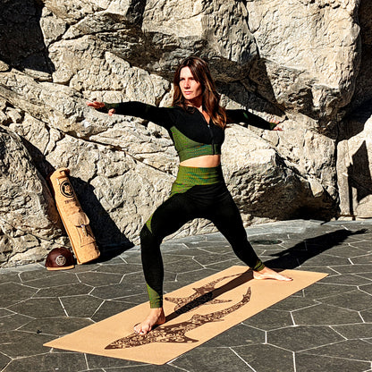 Yogini faisant la posture de yoga guerrier 2 sur le tapis en liège Koru Sharks de ZenMotion. Améliore votre posture et équilibre pour une pratique fluide et sereine, que ce soit en hatha yoga, vinyasa ou ashtanga. L'adhérence incomparable du liège, naturellement antidérapant, soutient chaque mouvement. Fabriqué à partir de matériaux naturels. Fabriqué à partir de matériaux naturels, durables et recyclables, ce tapis éco-responsable est une œuvre d'art fonctionnelle.