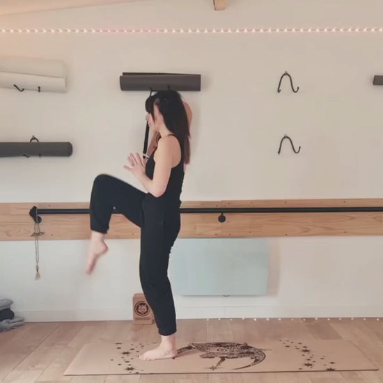 Yogini faisant un flow sur le tapis de yoga en liège Fairy Night de ZenMotion. Plongez dans un univers enchanté le tapis est capturé ici dans un champ bucolique sous un mimosa. Inspiré des fées, ce design délicat mêle motifs mandalas et une rose cachée, symbolisant légèreté, créativité et magie. Le liège naturel offre une adhérence ultime et un confort inégalé, parfait pour une pratique fluide de Hatha ou de Yin yoga. Éco-responsable et élégant, ce tapis transforme chaque séance.