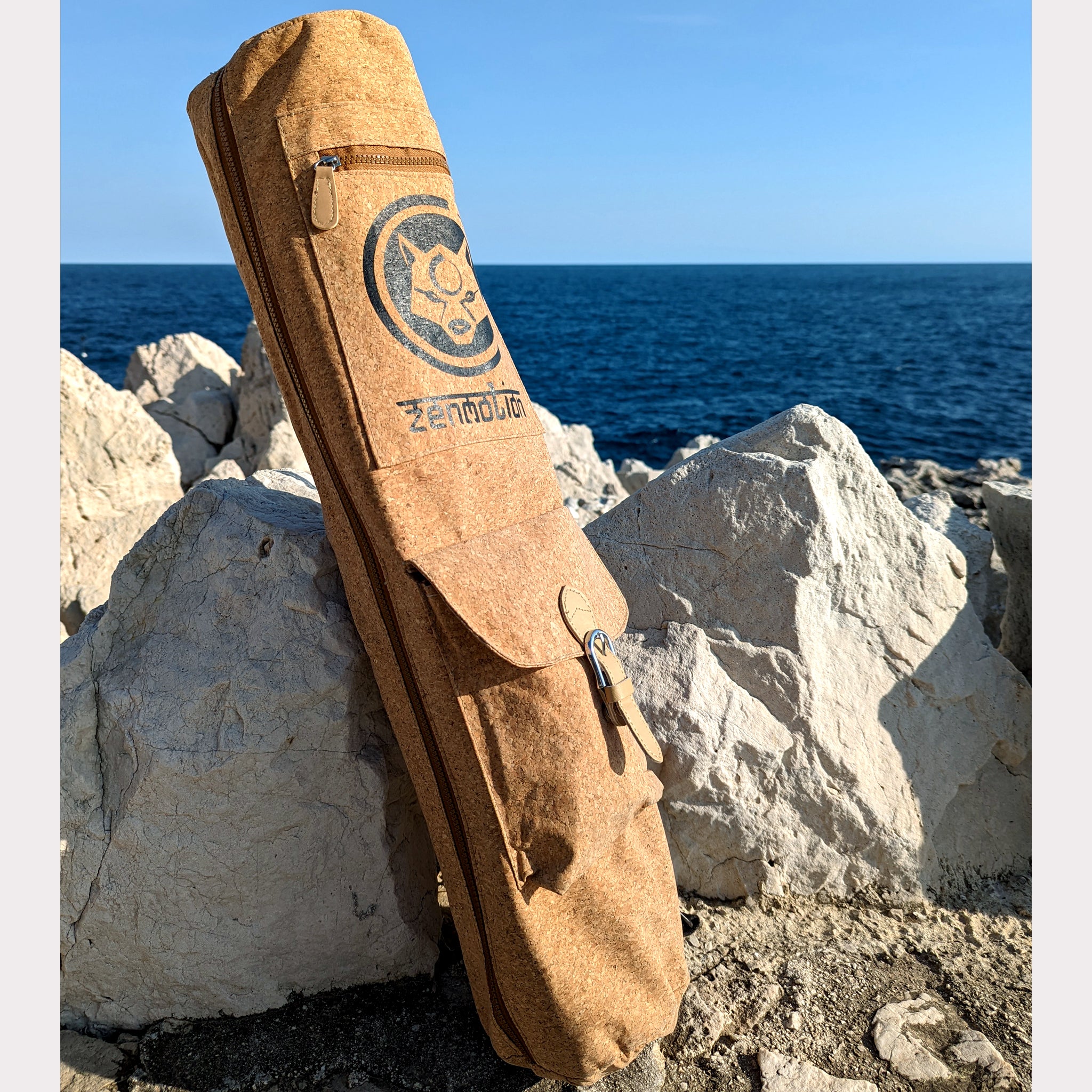 Le sac de transport en liège "Deluxe" de ZenMotion, présenté avec sa grande poche, est l'accessoire parfait pour les yogis exigeants. Ce modèle premium offre une poche spacieuse, fermée par une sangle en similicuir et une pression aimantée, idéale pour ranger vos sangles, élastiques ou autres accessoires de yoga. Facile à nettoyer et d'une finition élégante, il garantit une expérience de yoga pratique et stylée. Transportez votre tapis en toute simplicité tout en restant organisé et prêt à chaque séance.