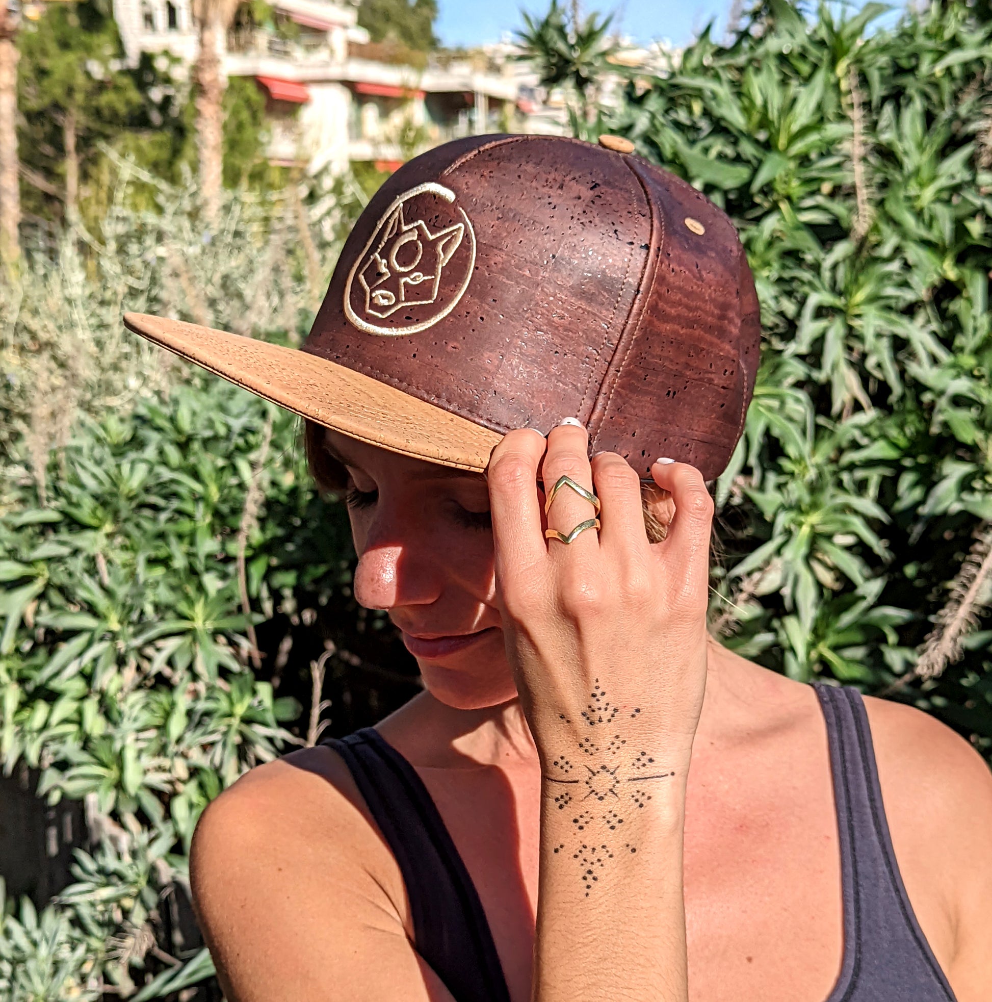 Femme portant une casquette en liège ZenMotion, un accessoire élégant et écologique conçu pour les amateurs de style et de confort. Fabriquée en cuir de liège durable, cette casquette offre une texture lisse, une résistance aux taches et une isolation thermique optimale, parfaite pour protéger du soleil lors de vos séances de yoga en extérieur ou de vos aventures estivales. Alliant esthétique et praticité, cette casquette incarne l’esprit éco-responsable de ZenMotion, complétant parfaitement votre tenue.